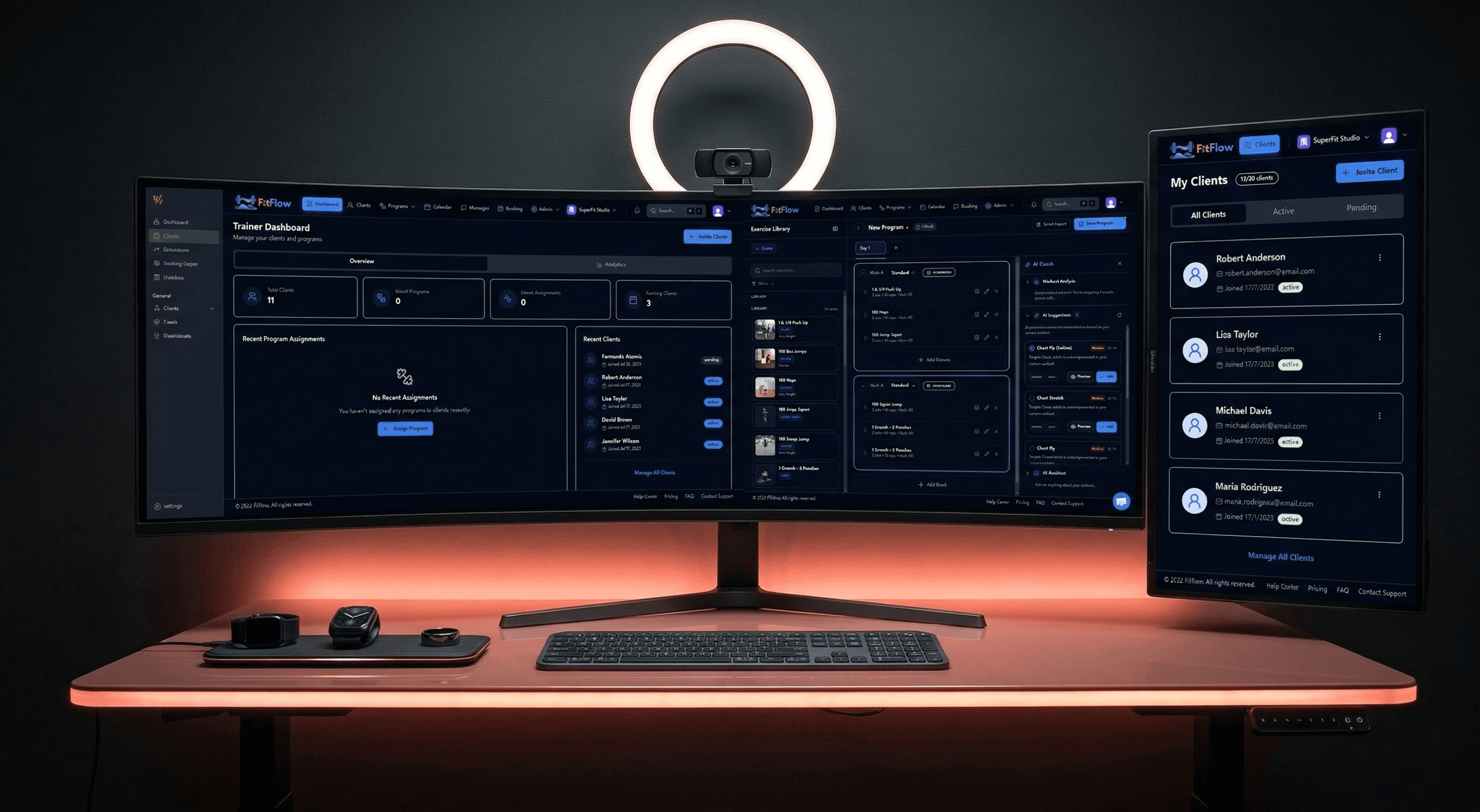 Fitness professional reviewing client analytics on a large monitor in a modern dark-mode workspace with wearable devices nearby